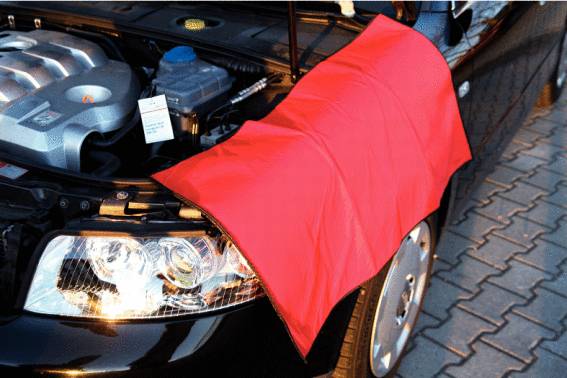 Motorhaube eines schwarzen Autos ist geöffnet, mit einer roten Schutzdecke über dem Kotflügel zum Schutz vor Kratzern beim Motorcheck.