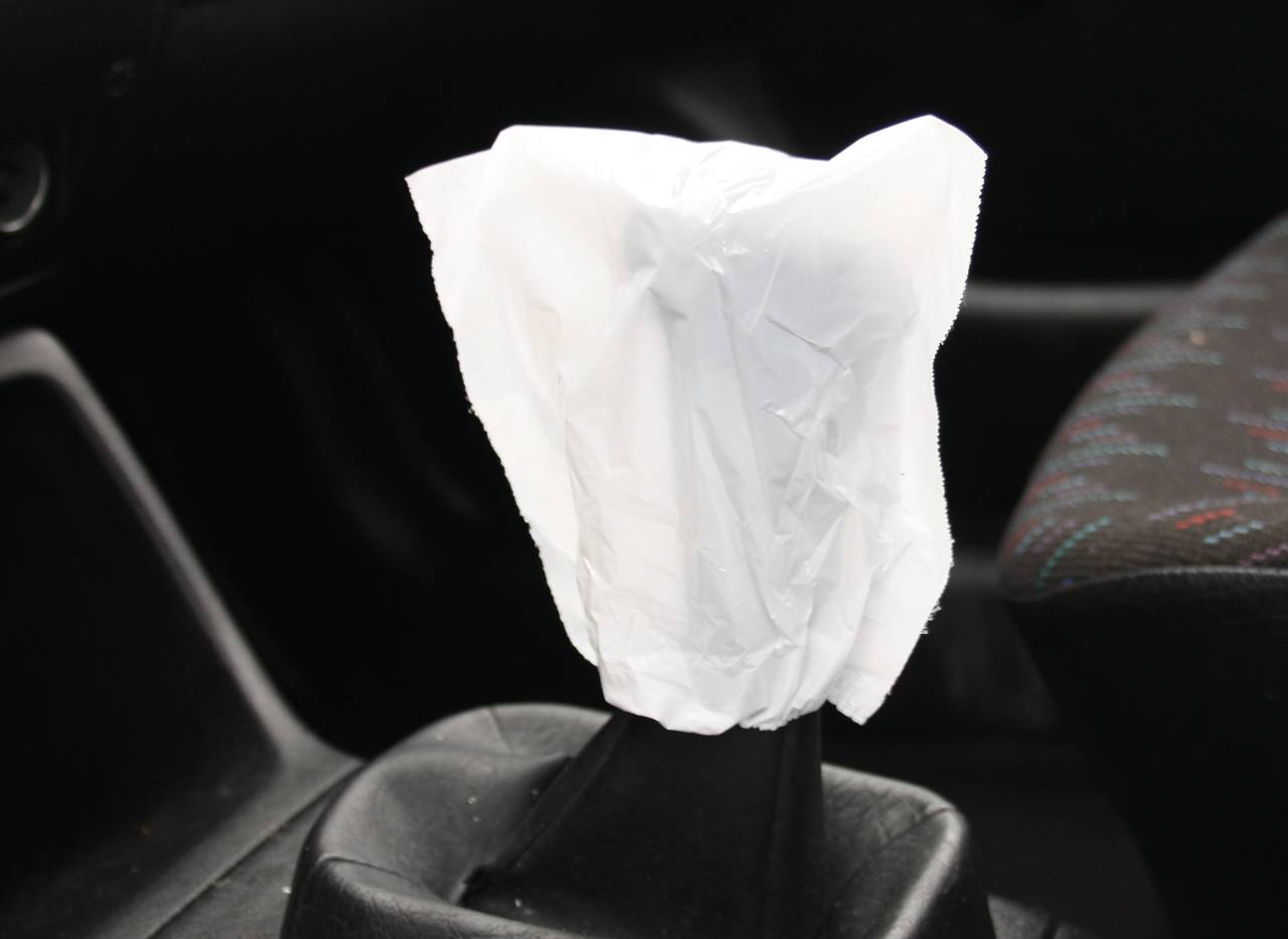 Ein Schalthebel in einem Auto ist mit einer weißem Plastikfolie umhüllt.