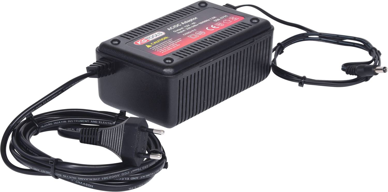 Schwarzes Netzteil mit zwei Kabeln; eines endet in einem Stecker. Aufkleber mit technischen Spezifikationen und Sicherheitshinweisen oben.