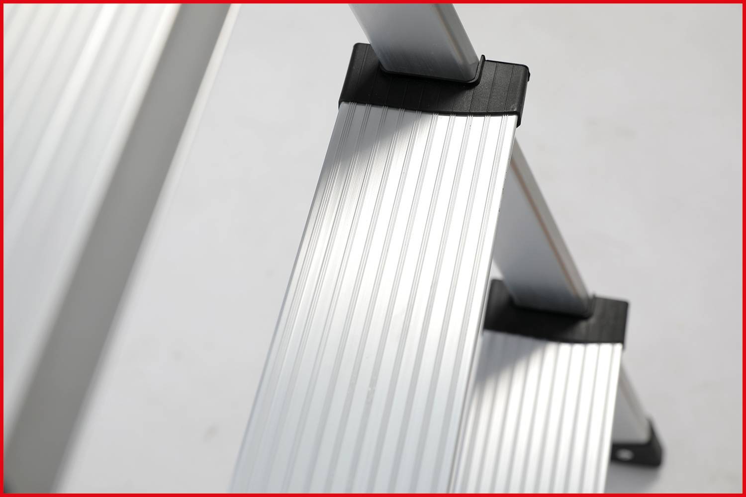 Metallene Stufen einer Leiter mit rutschfester Oberfläche, seitlicher Blickwinkel.