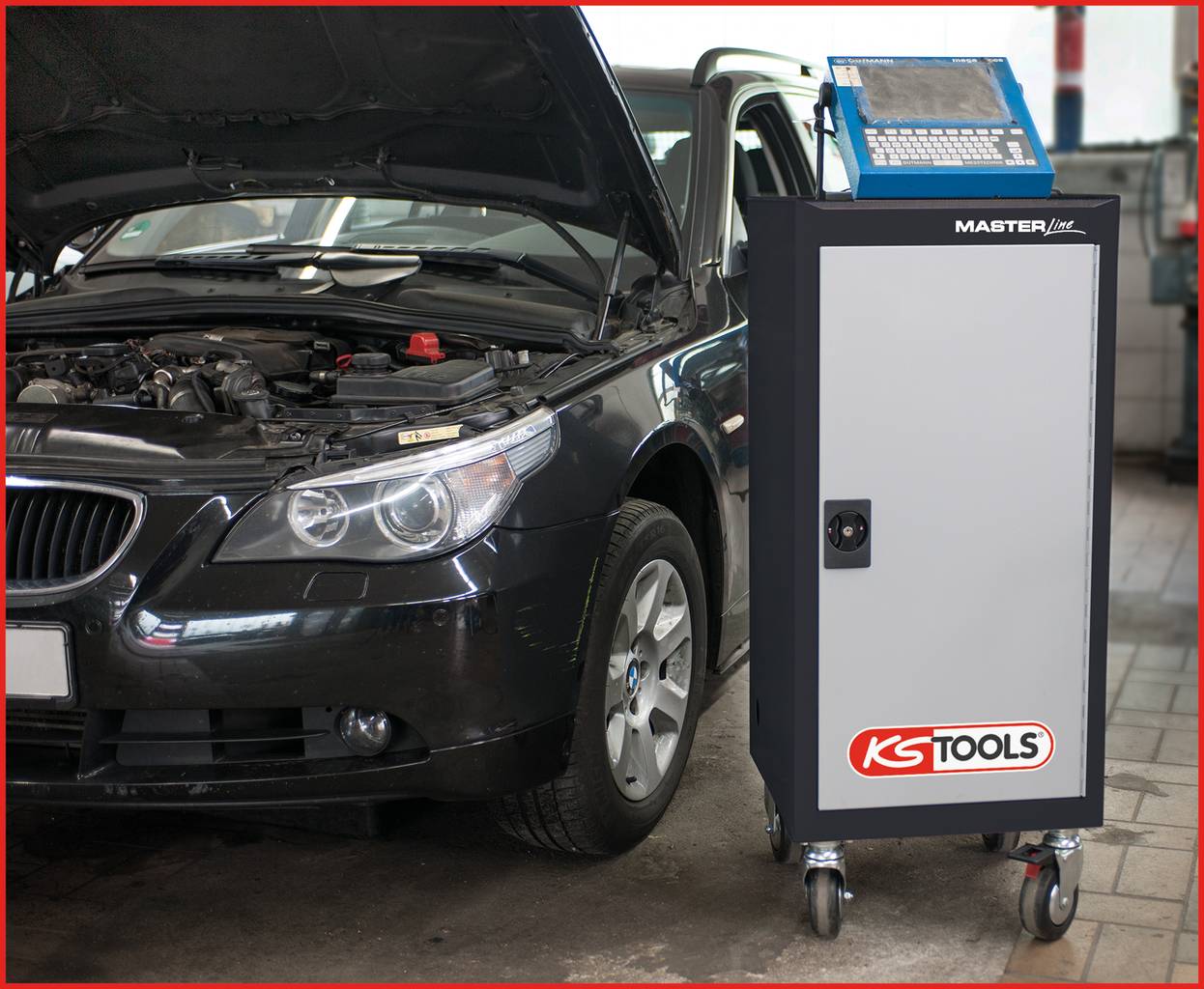 Ein Auto mit geöffneter Motorhaube steht in einer Werkstatt. Daneben ein Diagnosegerät mit Klemmbrett darauf, für Fahrzeugwartung.