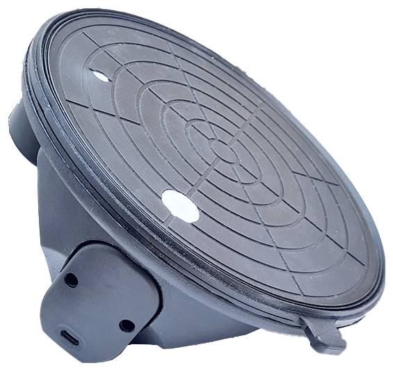 Ein schwarzer Abflussdeckel mit runden, konzentrischen Mustern in der Mitte; seitliche Klammern zur Befestigung sichtbar.