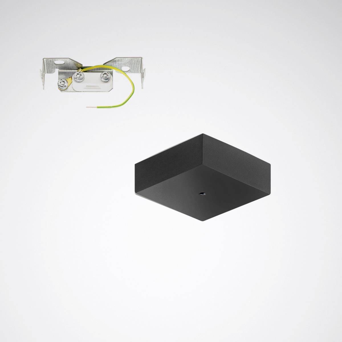 Ein schwarzer Würfel neben einer Metallhalterung mit grün-gelbem Kabel.