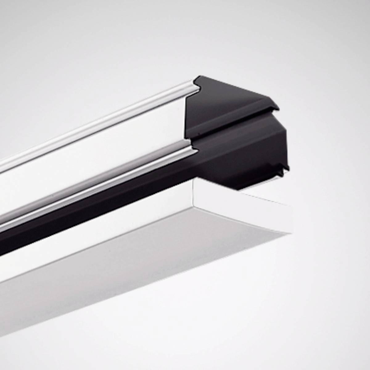 Deckenbefestigtes Beleuchtungssystem mit einem schlanken, modernen Design aus schwarz-weißem Material, schräg von unten fotografiert.