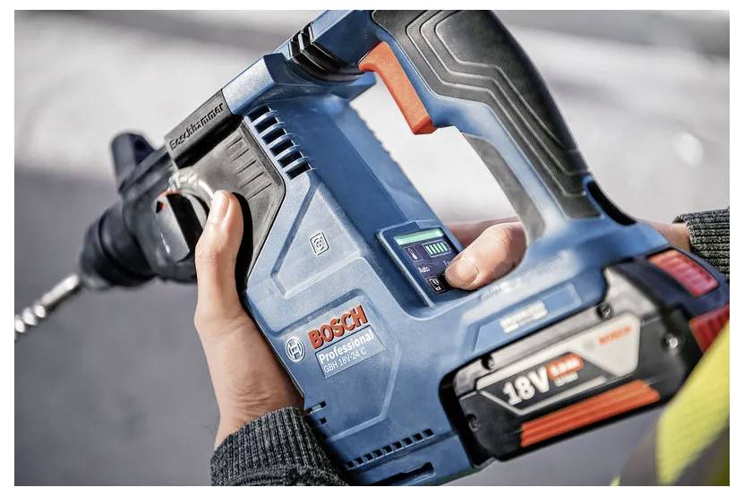 Eine Person hält eine blaue Bosch Professional 18V Bohrmaschine und zeigt deren kabelloses Design und ergonomischen Griff, bereit zum Einsatz.