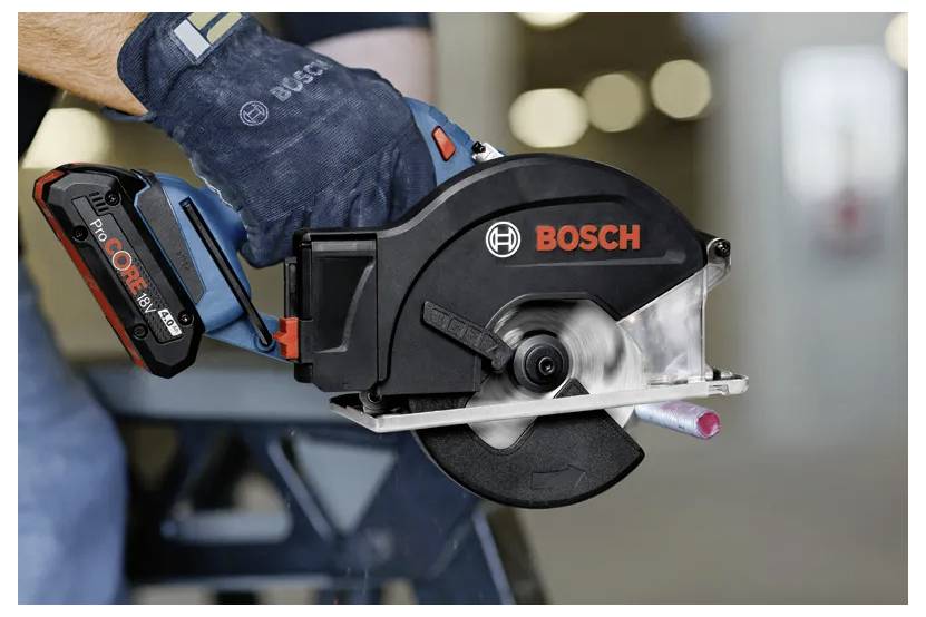 Eine Person hält eine Bosch-Elektrosäge und schneidet eine Metallstange. Die Säge ist mit einem CORE18V-Akku ausgestattet und wird in einer industriellen Umgebung verwendet.