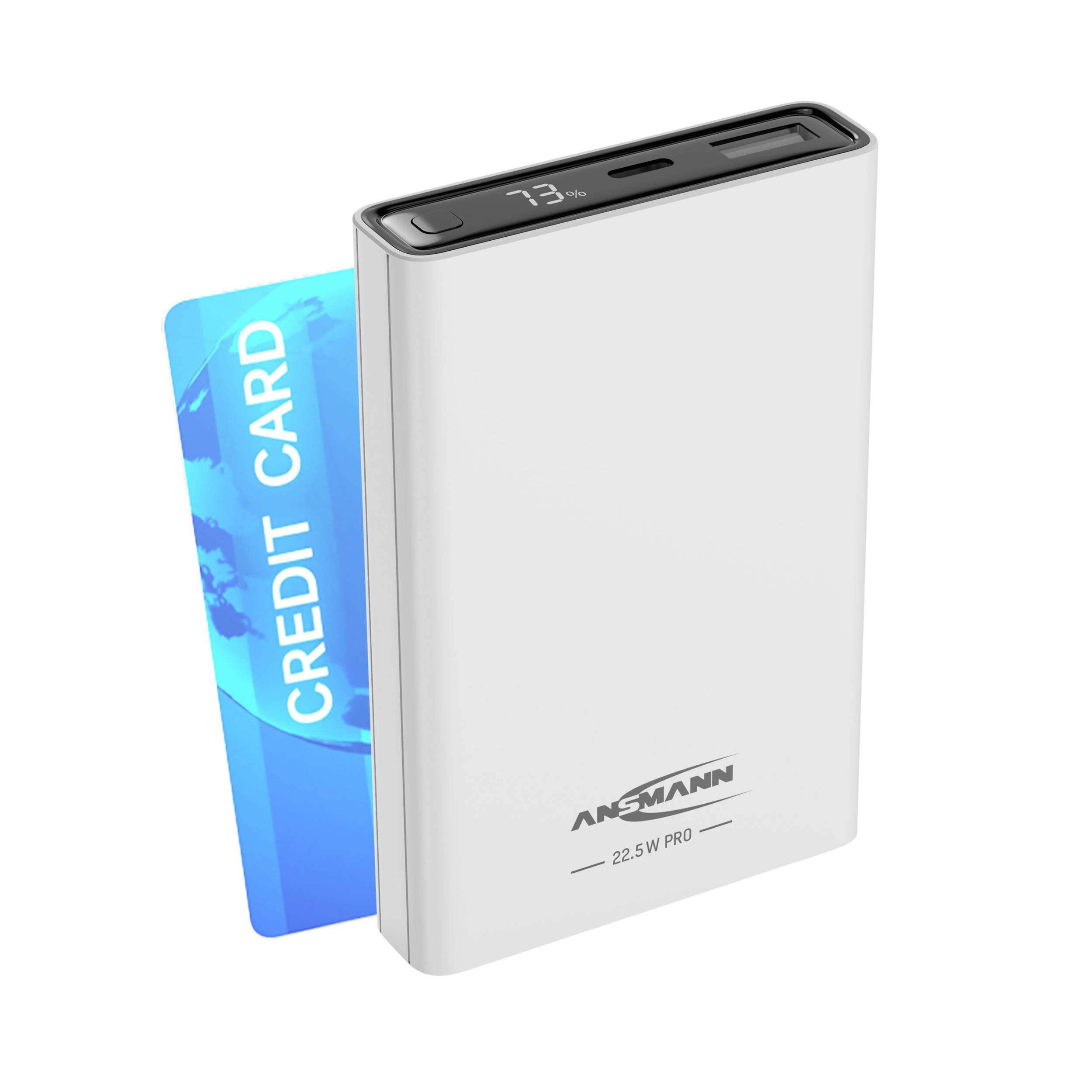 Weiße Powerbank mit digitaler Anzeige und USB-Anschlüssen, neben blauer Kreditkarte; zeigt kompakte Größe und Tragbarkeit.
