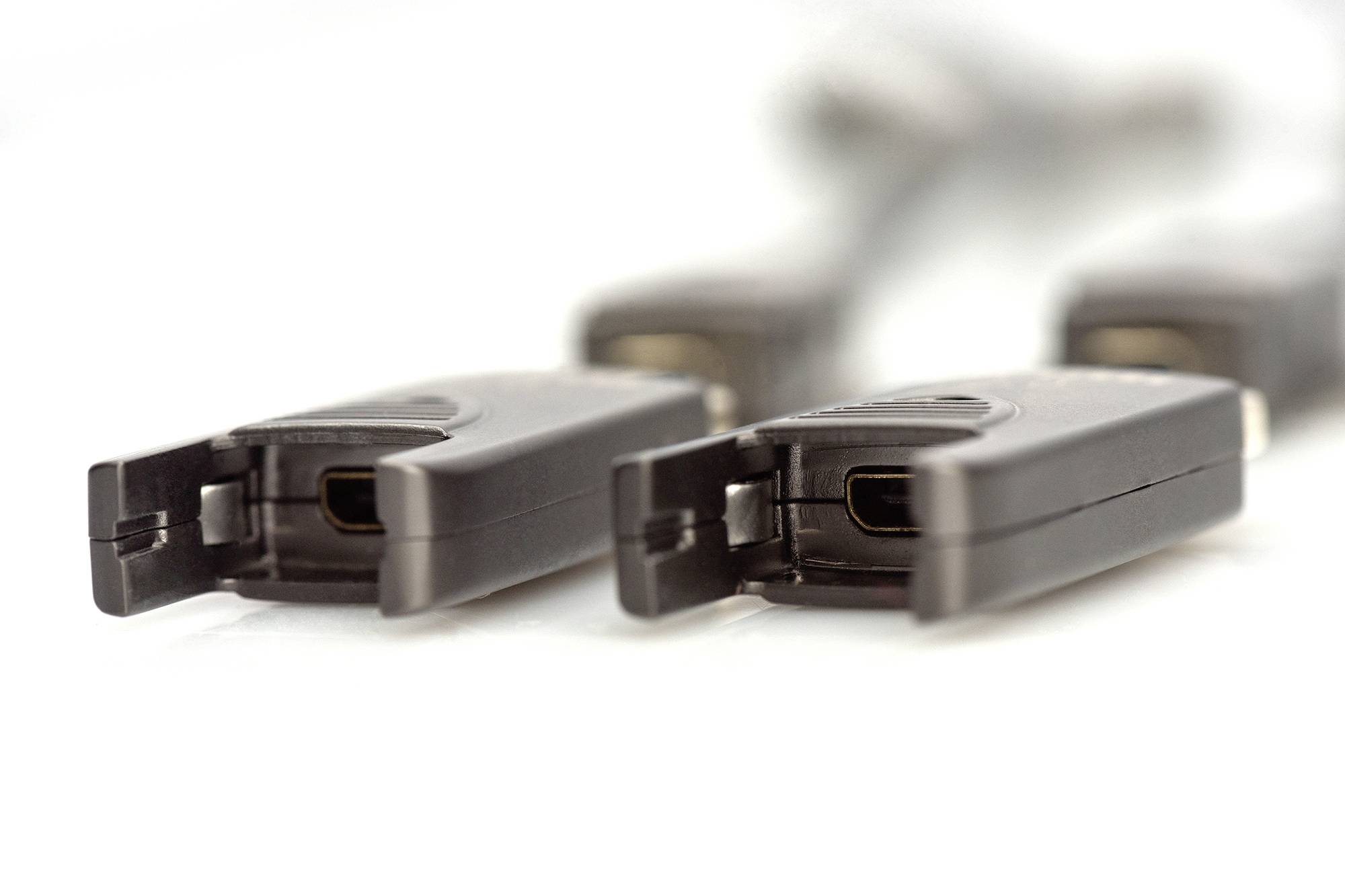 Mehrere USB-Kabel mit USB-C-Anschlüssen in Nahaufnahme, nebeneinander auf einem weißen Hintergrund liegend.