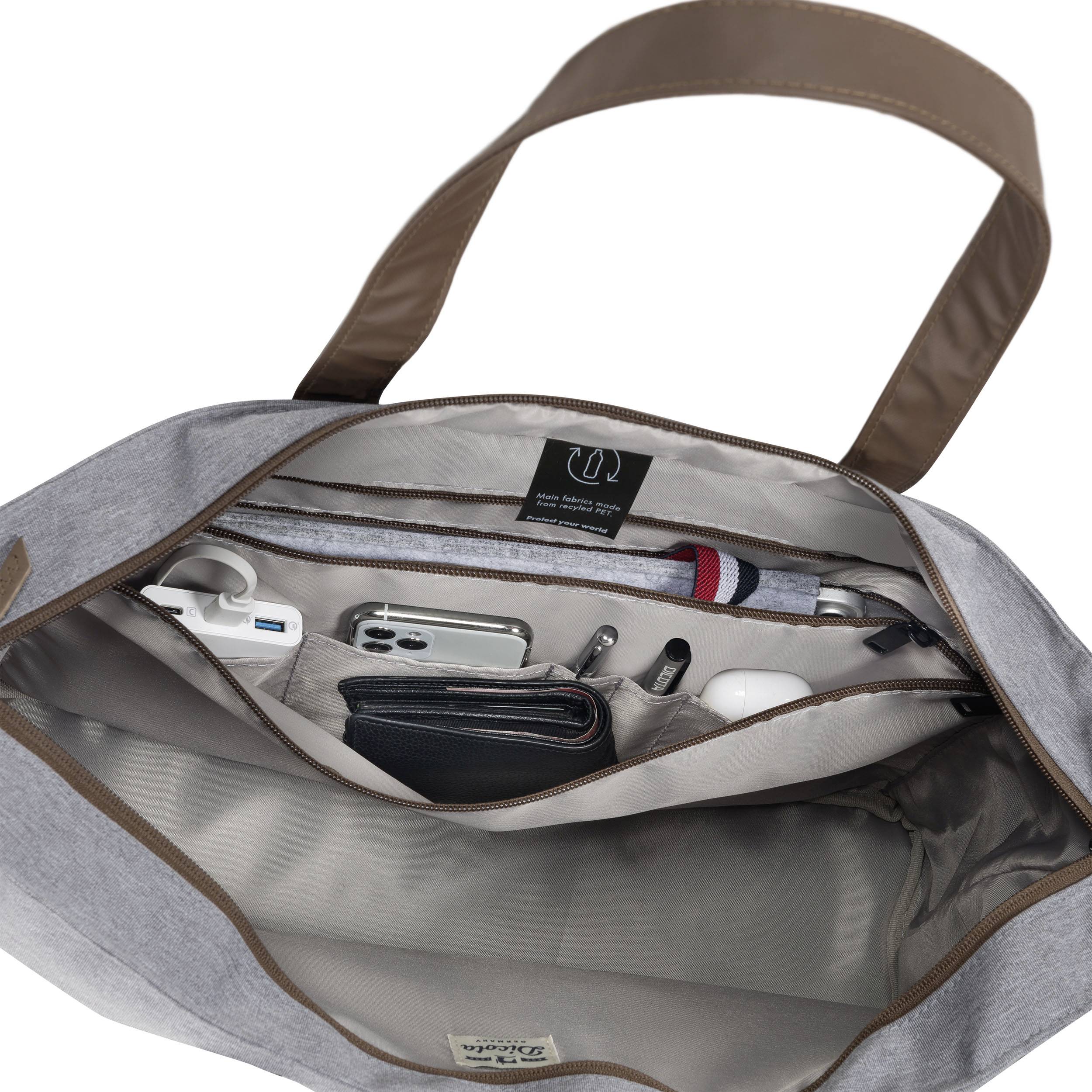 Geöffnete graue Handtasche zeigt geordnete Innenfächer mit einem Smartphone, Kopfhörern, Stiften und einem Portemonnaie.