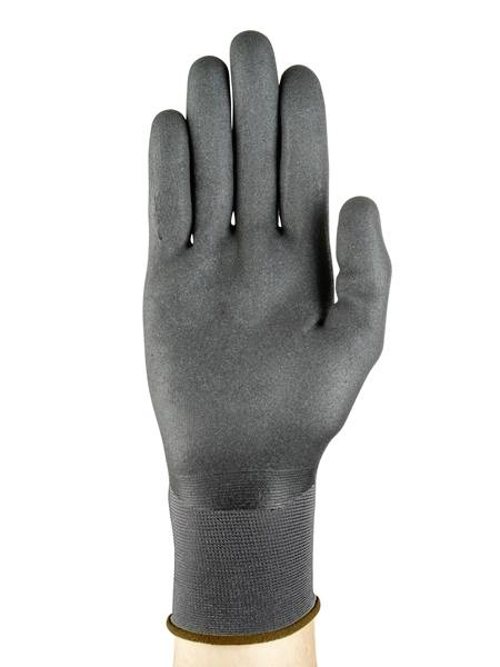 Ein schwarzer Handschuh auf einer Hand. Der Handschuh hat eine glatte Oberfläche und reicht bis kurz über das Handgelenk.