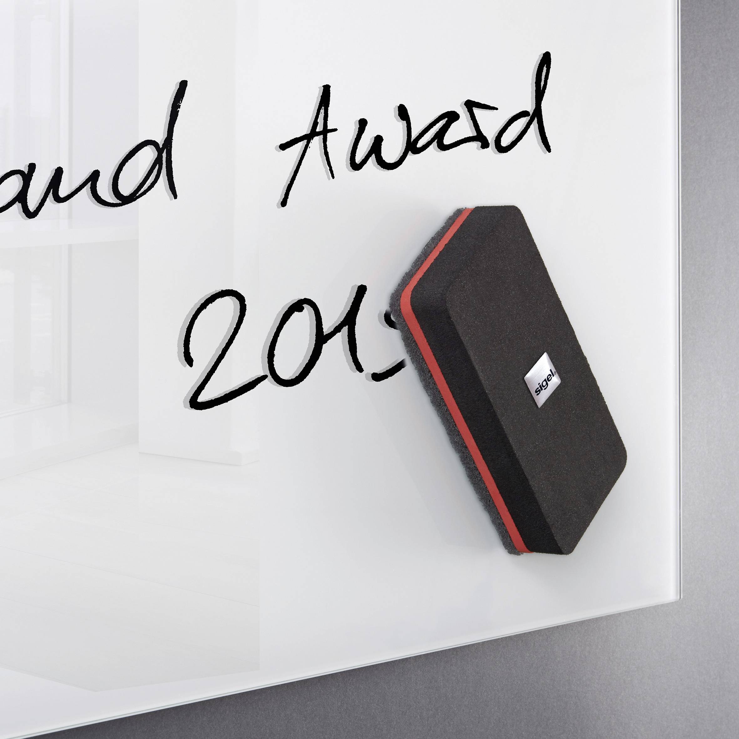 Ein Whiteboard mit schwarzer Schrift 'Award 2015'. Ein Tafelschwamm liegt daneben.