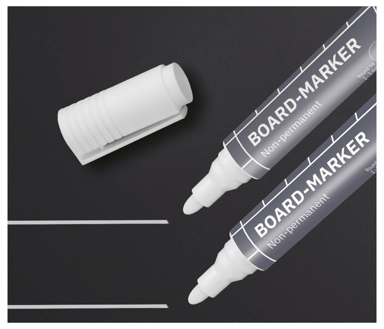 Zwei weiße Whiteboard-Marker und eine separate Kappe auf einer schwarzen Oberfläche, darunter zwei dünne weiße Linien.