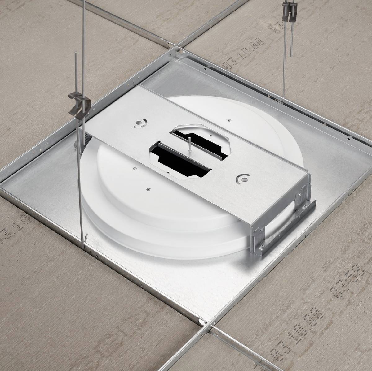 Installation einer runden weißen Deckenleuchte in einem quadratischen Metallrahmen an einer Rohdecke.