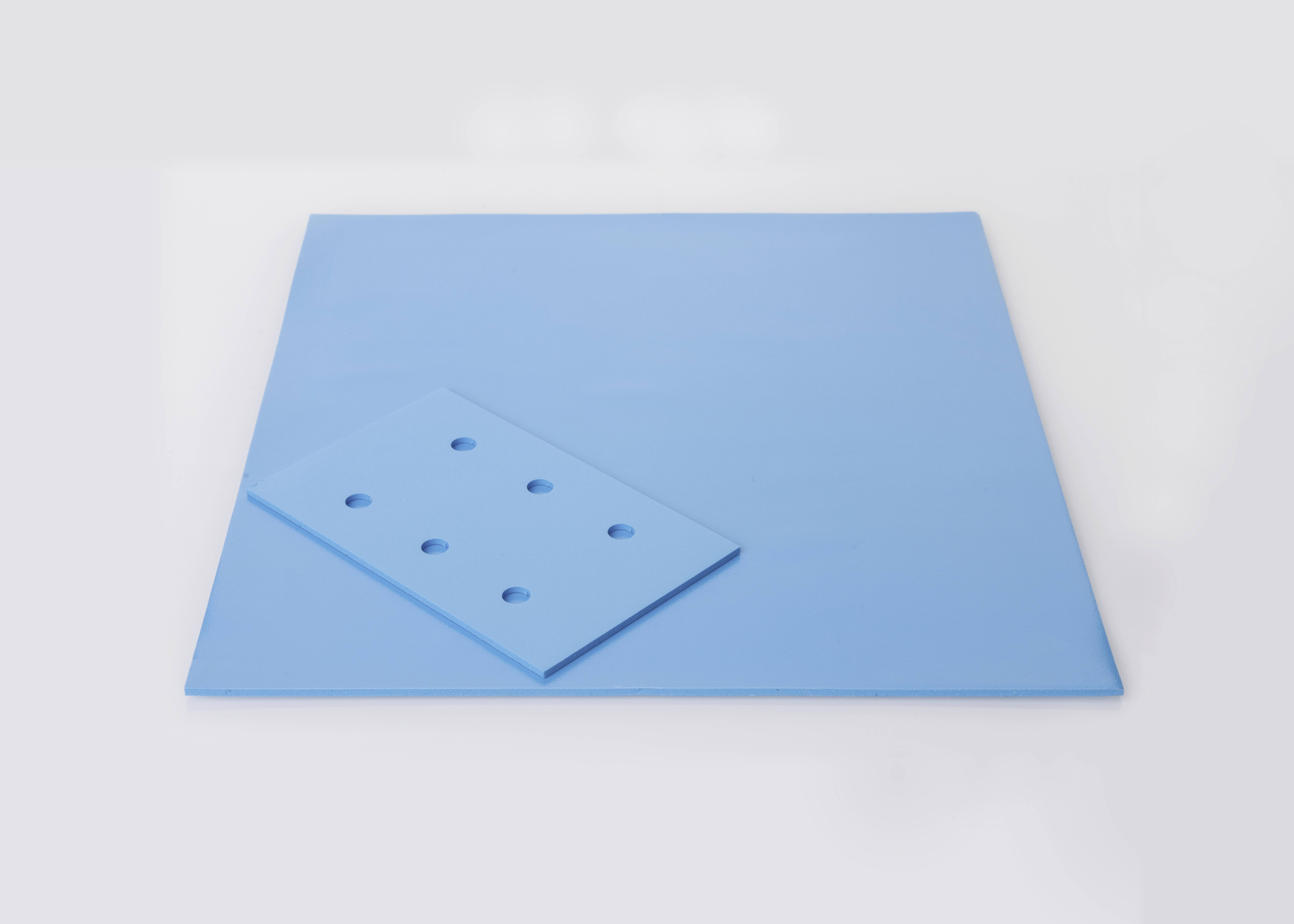 Ein großes blaues Quadrat und ein kleineres blaues Rechteck, beide mit runden Löchern.