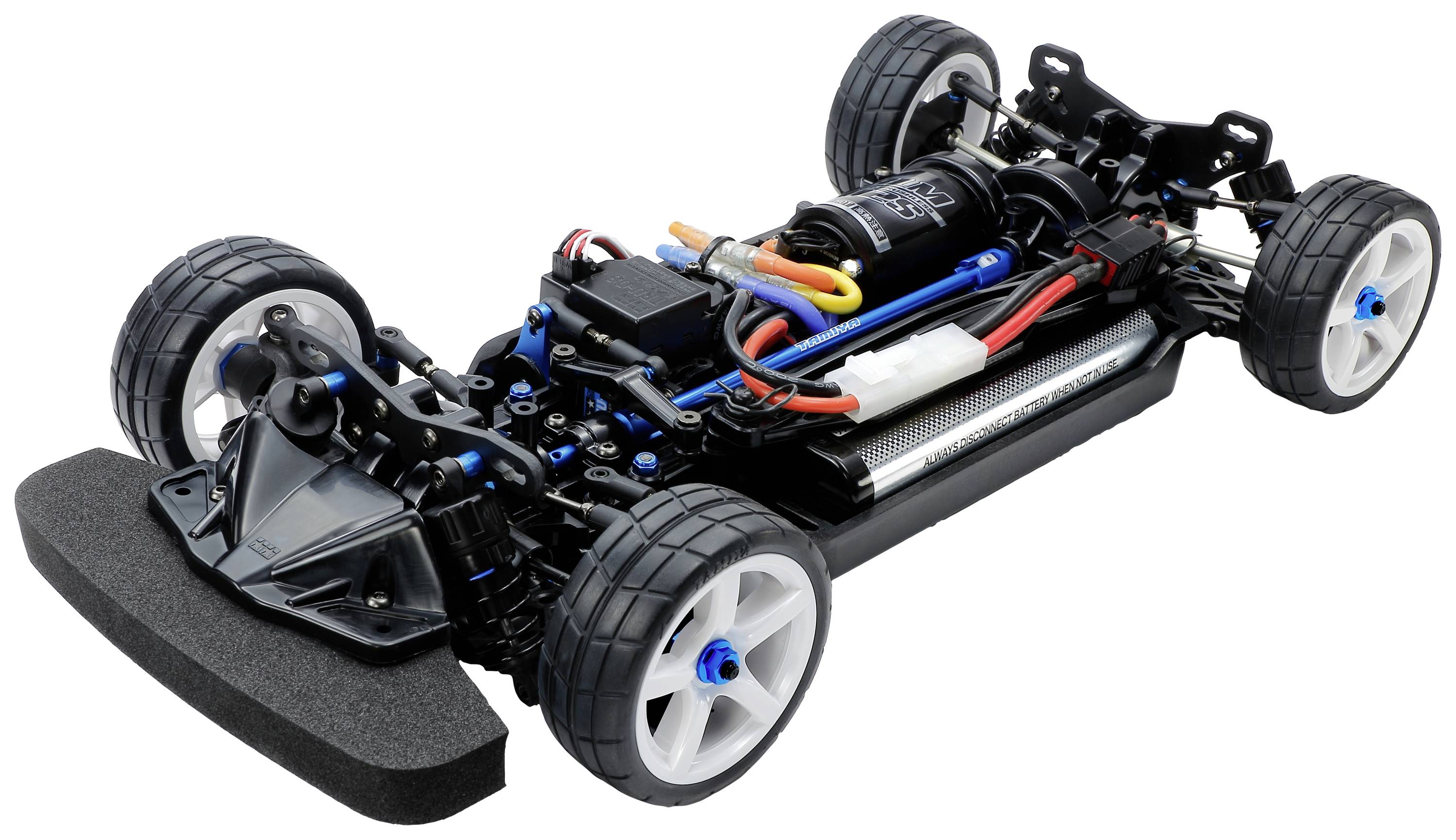 Ein ferngesteuertes Autochassis mit sichtbaren Motoren, Batterie und Kabeln, auf vier Rädern. Modell für elektrische RC-Fahrzeuge.