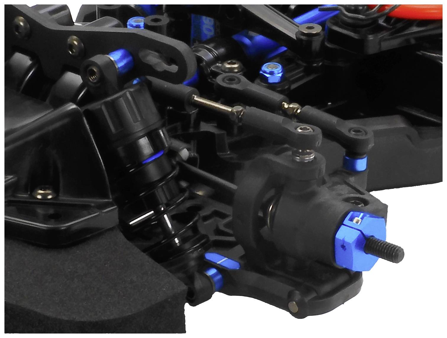 Nahaufnahme eines ferngesteuerten Autoteils, zeigt die Federung und blaue Aluminiumkomponenten.