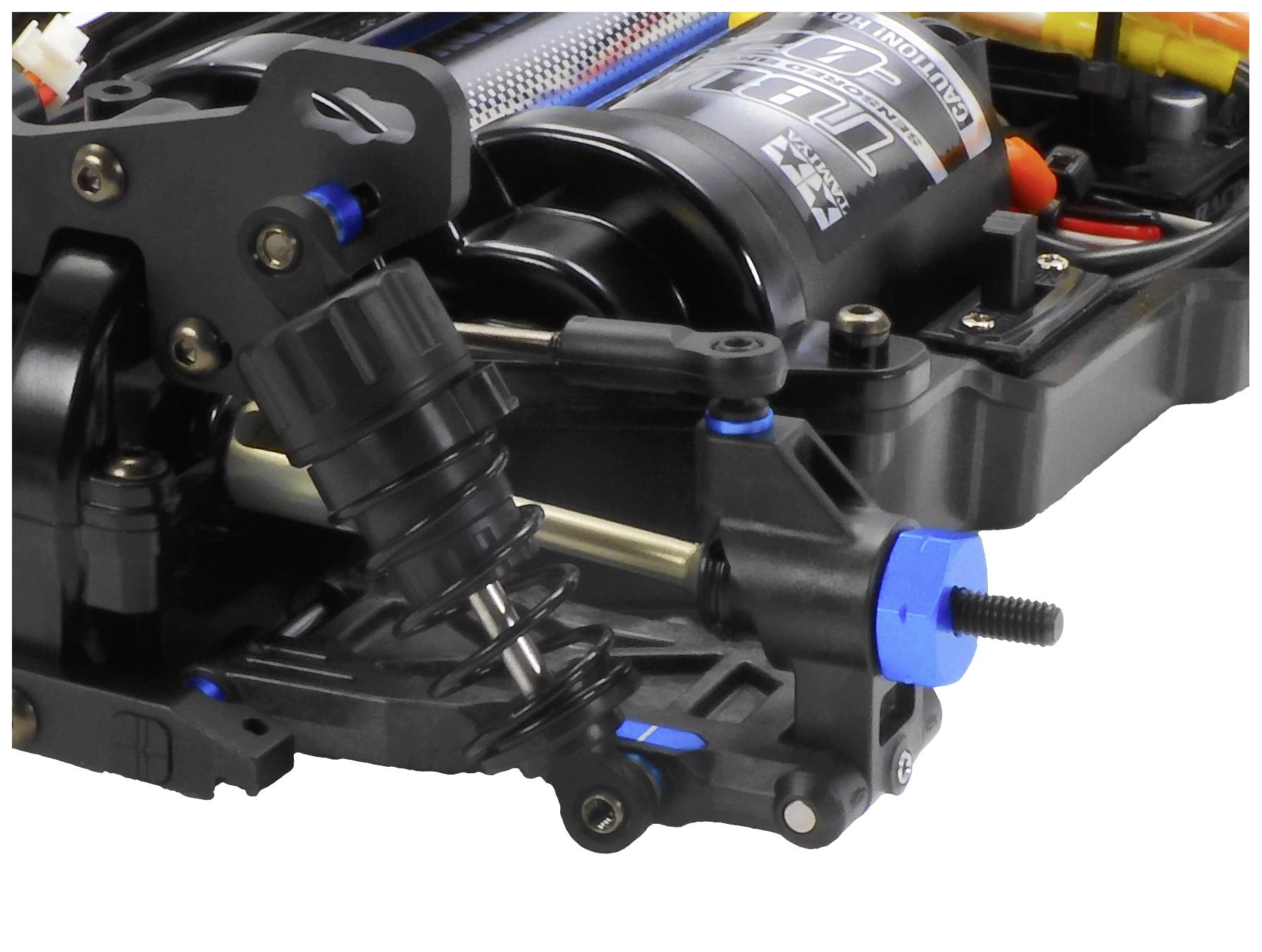 Nahaufnahme eines elektrischen RC-Auto-Fahrwerks mit Motor, Dämpfer und Kabelverbindungen. Fokus auf technische Details und Bauweise.