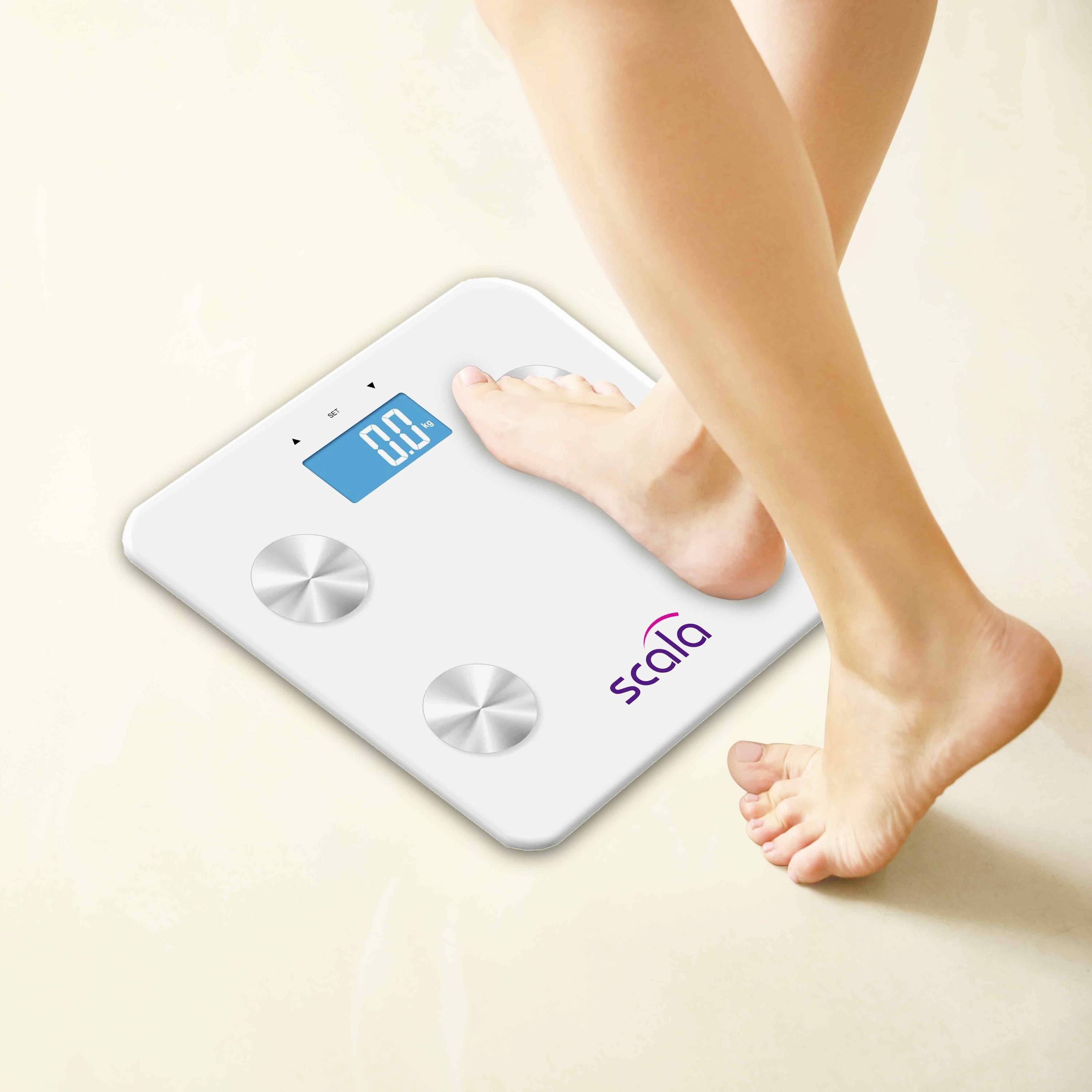 Ein Fuß steht auf einer digitalen Personenwaage mit blau leuchtendem Display, das Gewicht anzeigt. Die Waage ist weiß mit silbernen Sensoren.