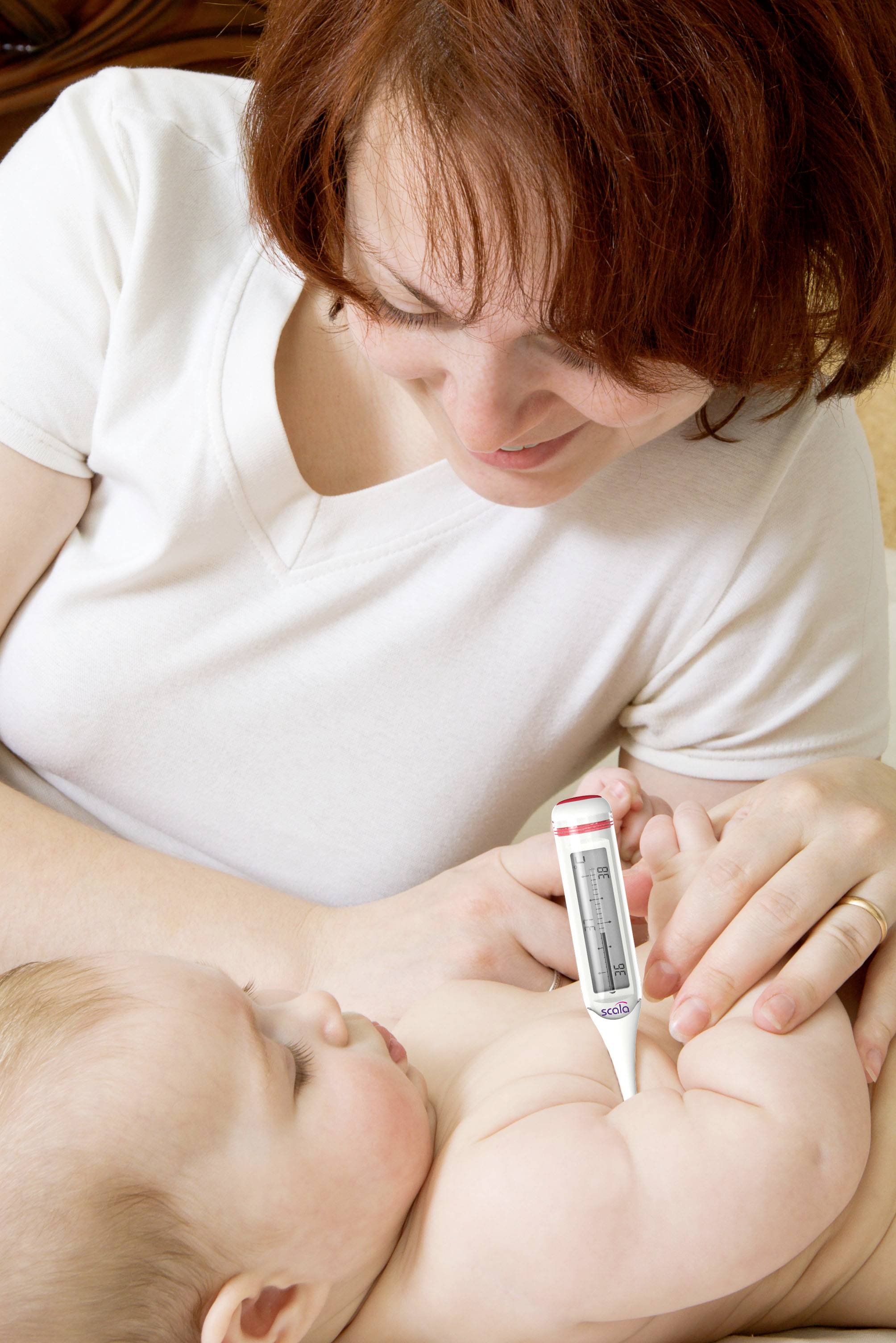 Eine Frau misst mit einem digitalen Thermometer die Temperatur eines Babys, das auf ihrem Arm liegt.