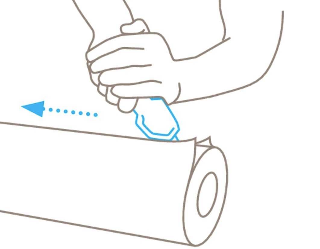 Eine Hand benutzt ein blaues Werkzeug, um eine Rolle Papier von links nach rechts zu schneiden.