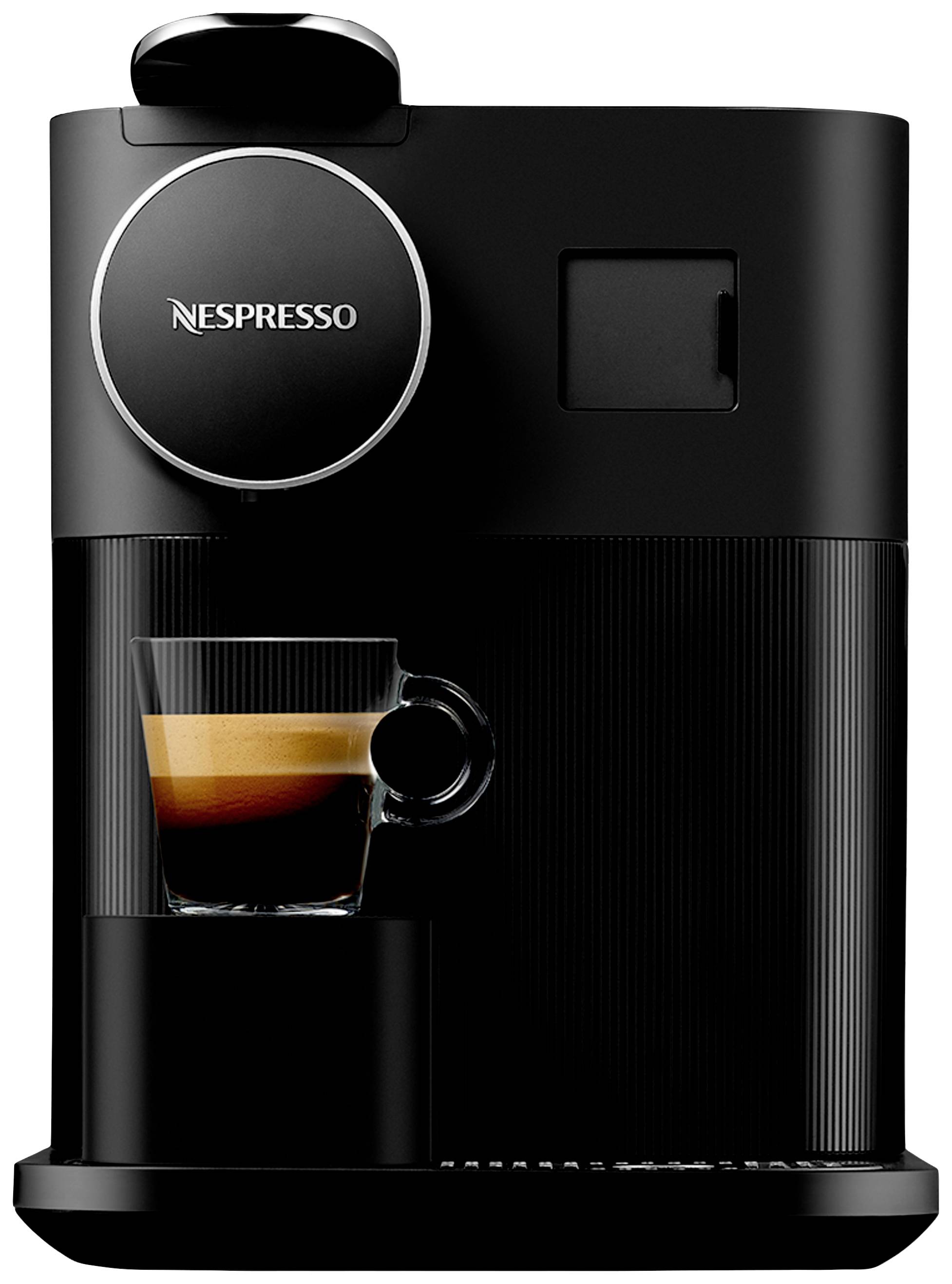 Eine schwarze Kaffeemaschine mit der Aufschrift 'Nespresso', die eine Tasse Espresso zubereitet.