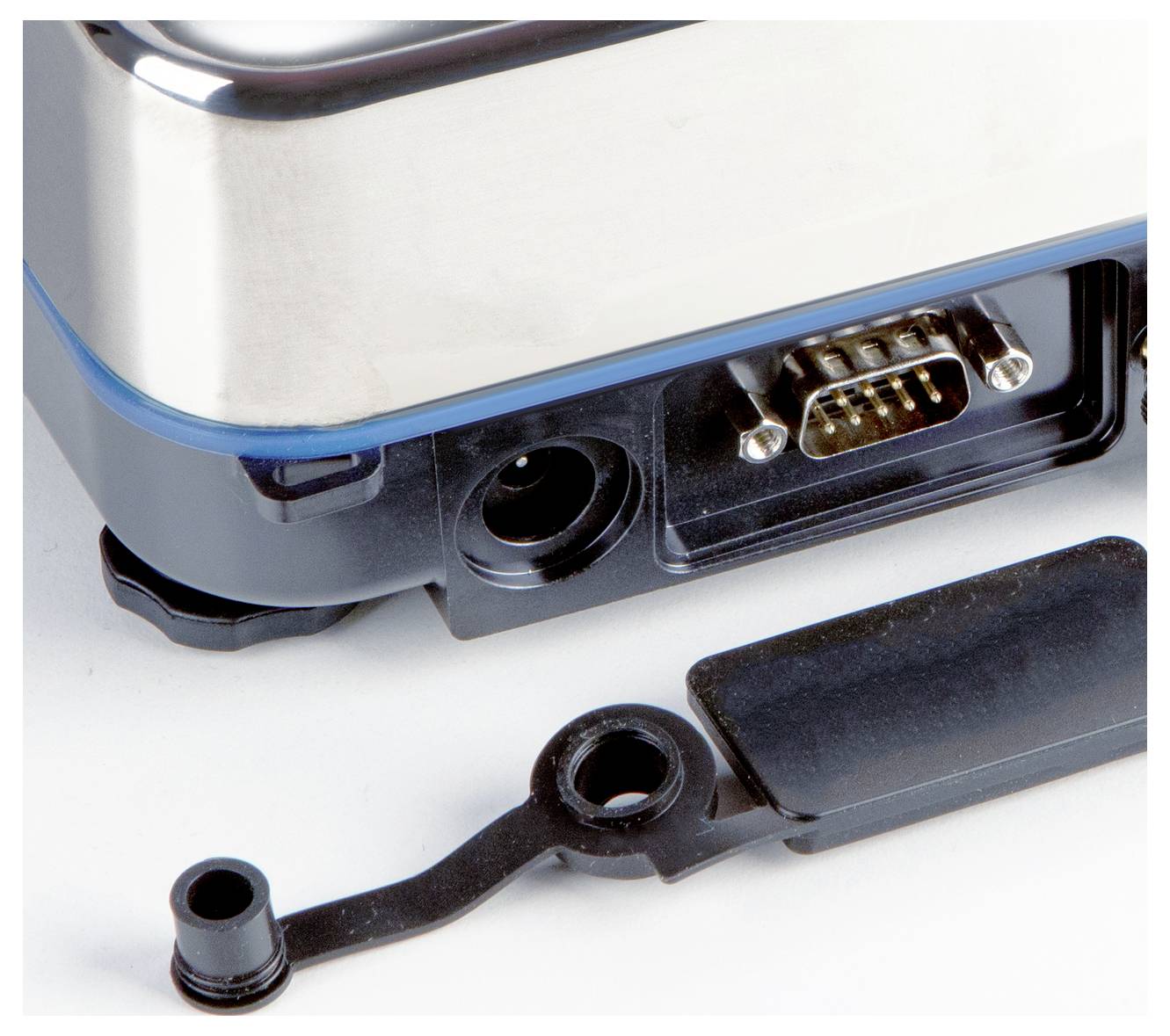 Eine Nahaufnahme eines elektronischen Geräts mit einem freigelegten seriellen Anschluss und einem entfernten Kunststoffdeckel.