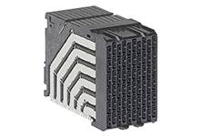 Ein schwarzes, blockförmiges Steckverbindergehäuse mit mehreren Reihen rechteckiger Ports. Geeignet für elektronische Verbindungen.