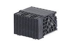 Schwarzes Kunststoffteil, das einem Würfel ähnelt, mit mehreren Gittern und strukturierten Oberflächen.