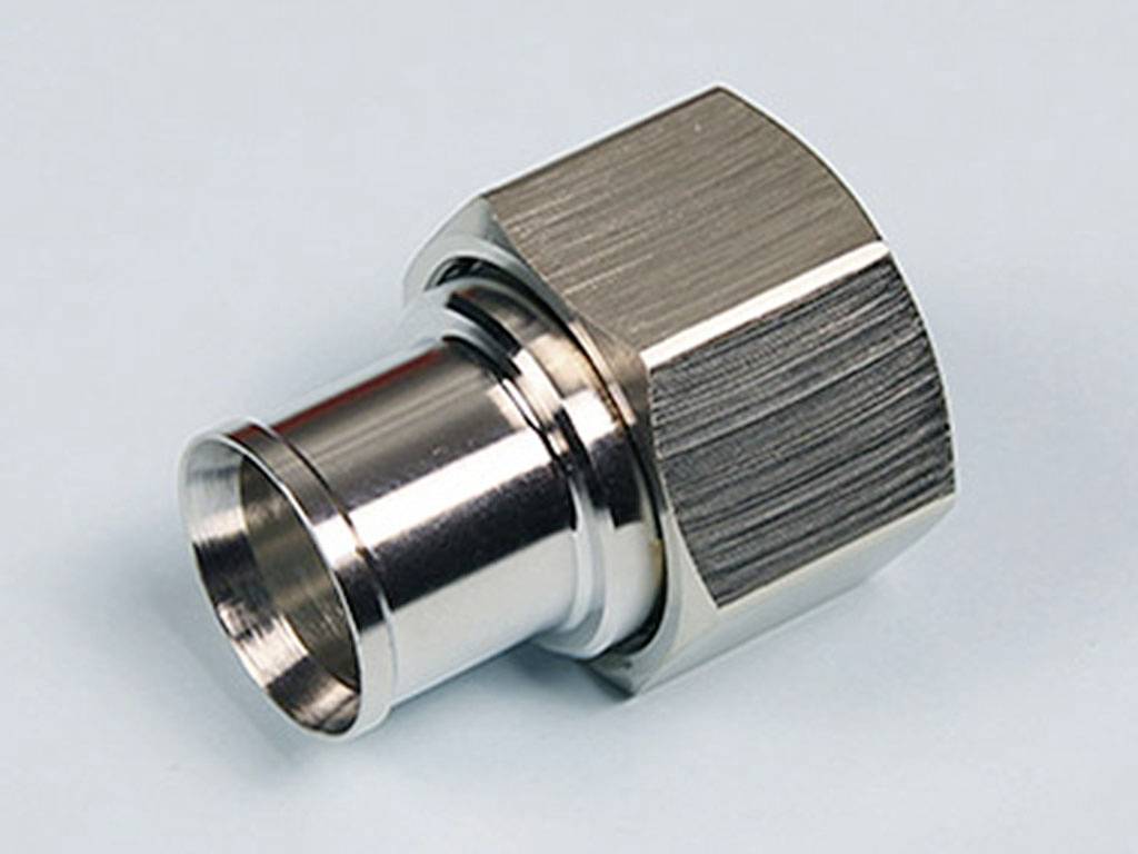 Metallischer Adapter für Rohrverbindungen mit sechseckiger Mutter und zylindrischem Anschluss, geeignet für industrielle Anwendungen.