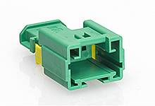 Grüner rechteckiger Stecker mit gelben Innenelementen auf weißem Hintergrund. Elektronikbauteil für Verbindungszwecke.