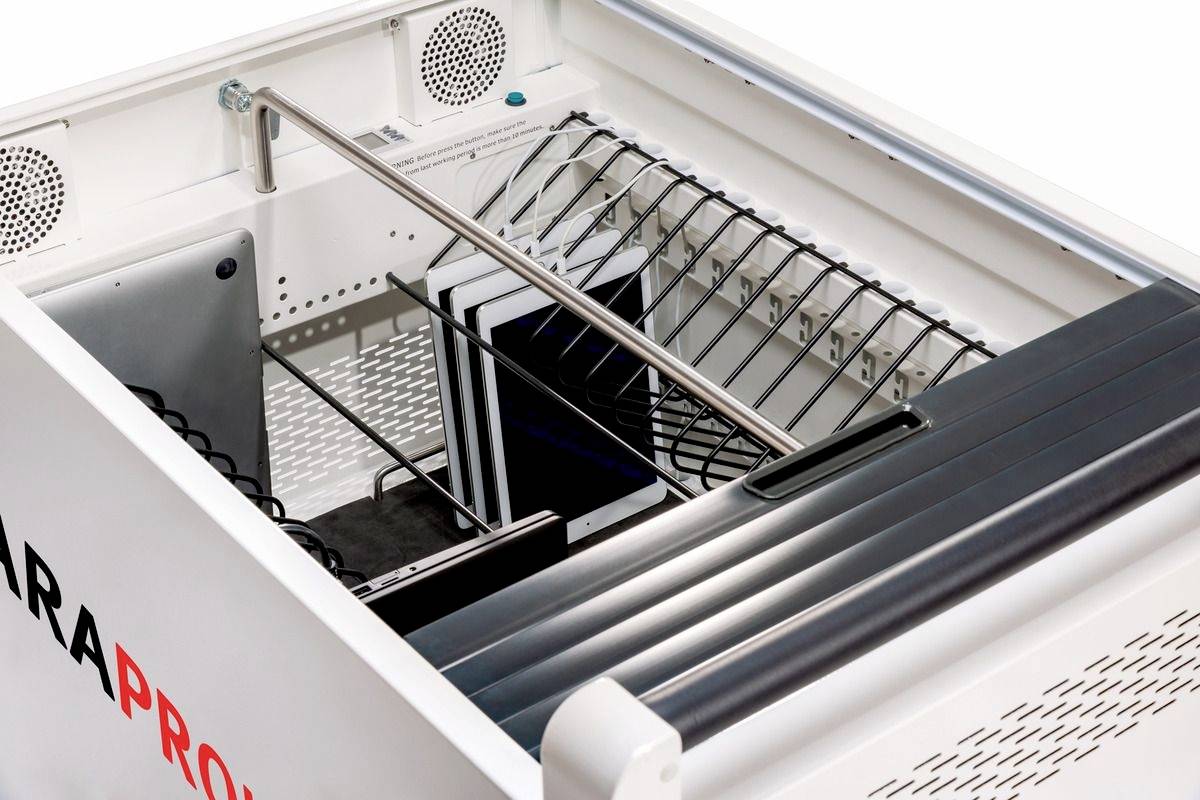 Innenansicht einer industriellen Waschmaschine mit Metallgestellen und Schläuchen, die auf das Reinigen von Gegenständen vorbereitet ist.