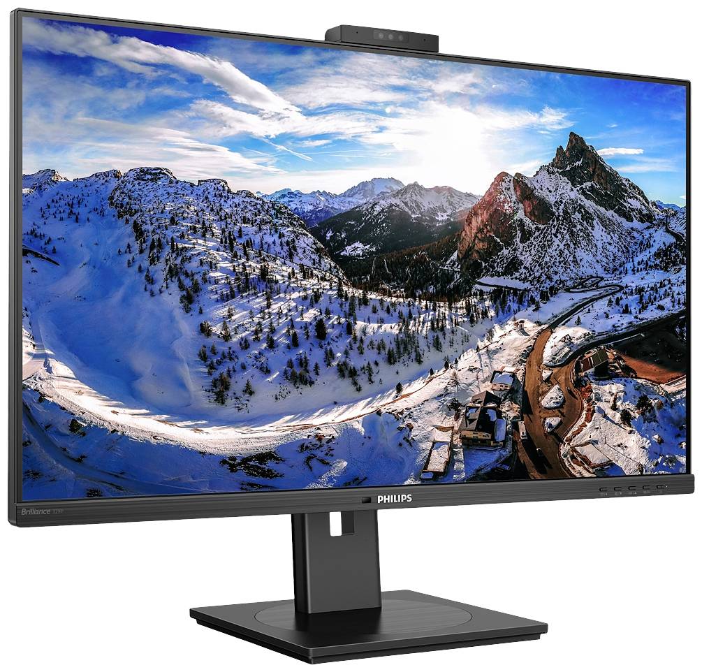 Ein Computermonitor zeigt eine schneebedeckte Berglandschaft bei Sonnenuntergang, mit klar blauem Himmel und dramatischen Wolken.