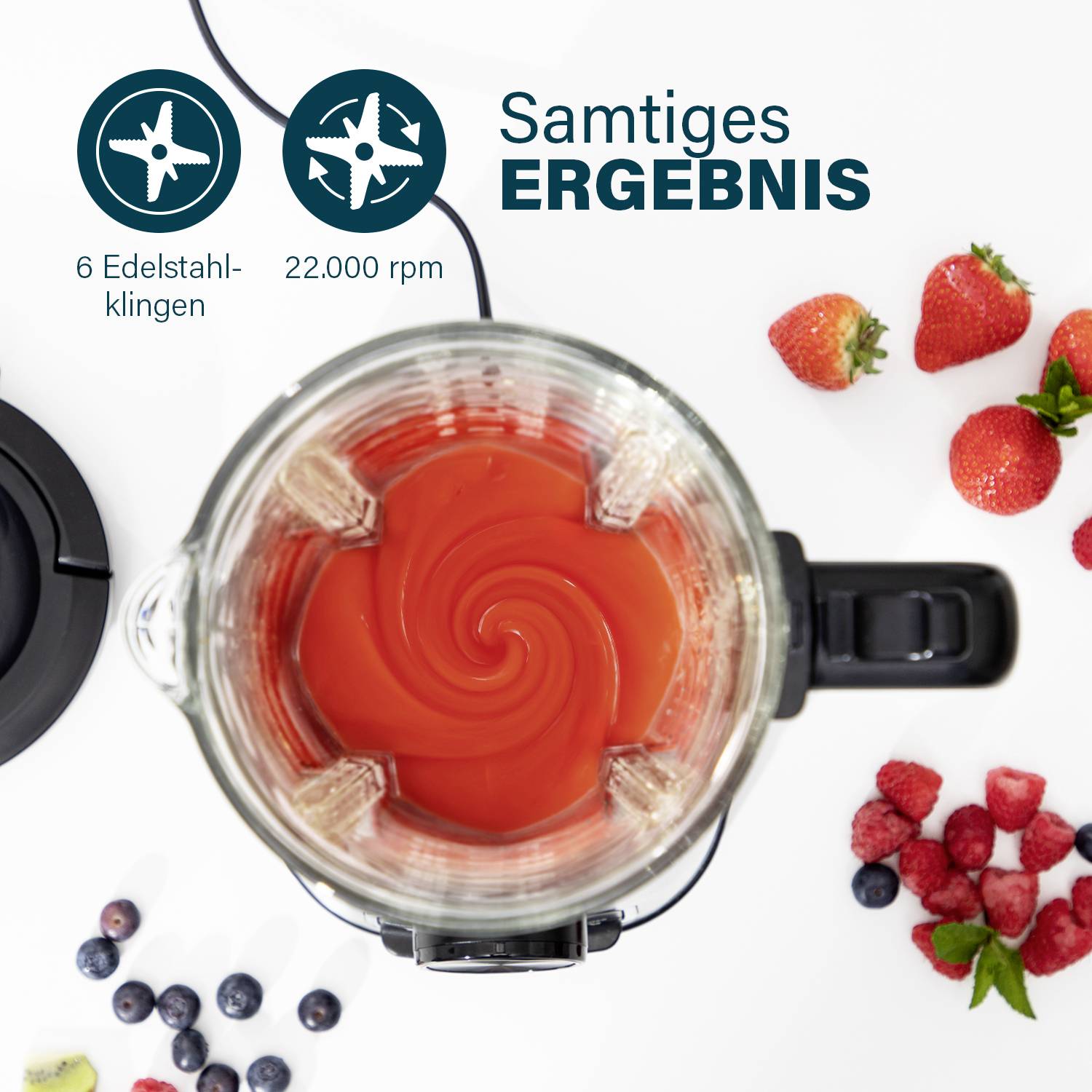 Ein Mixer von oben mit rotem Inhalt, umgeben von Erdbeeren und Blaubeeren. Text: 6 Edelstahlklingen, 22.000 rpm, Samtiges Ergebnis.