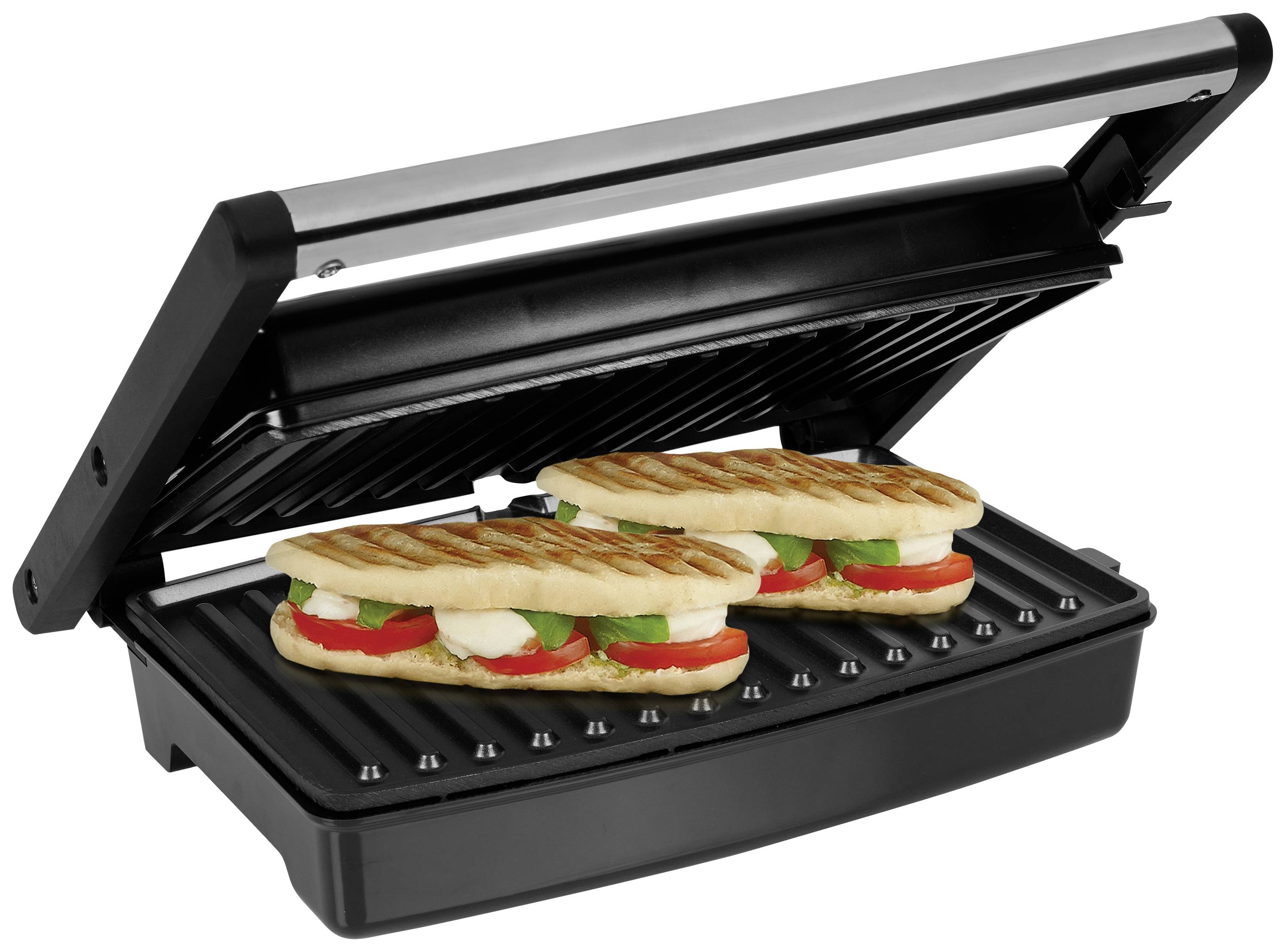 Zwei Panini-Sandwiches mit Tomaten, Mozzarella und Basilikum werden auf einem Kontaktgrill erhitzt.