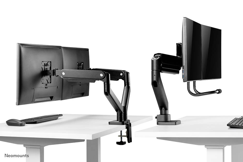 Zwei Monitore sind mit flexiblen Halterungen an separaten Schreibtischen montiert. Die Halterungen ermöglichen eine verstellbare Positionierung.
