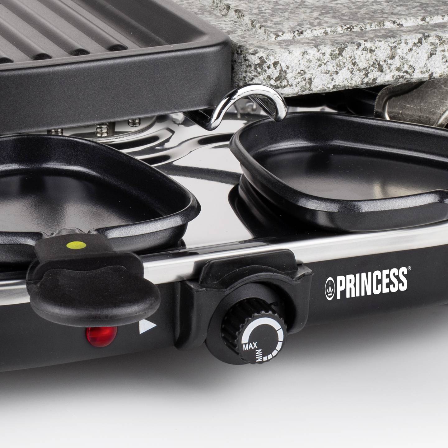 Elektrischer Raclette-Grill 'Princess' mit zwei Pfännchen und Heizplatte, Temperaturregler auf Maximum eingestellt.