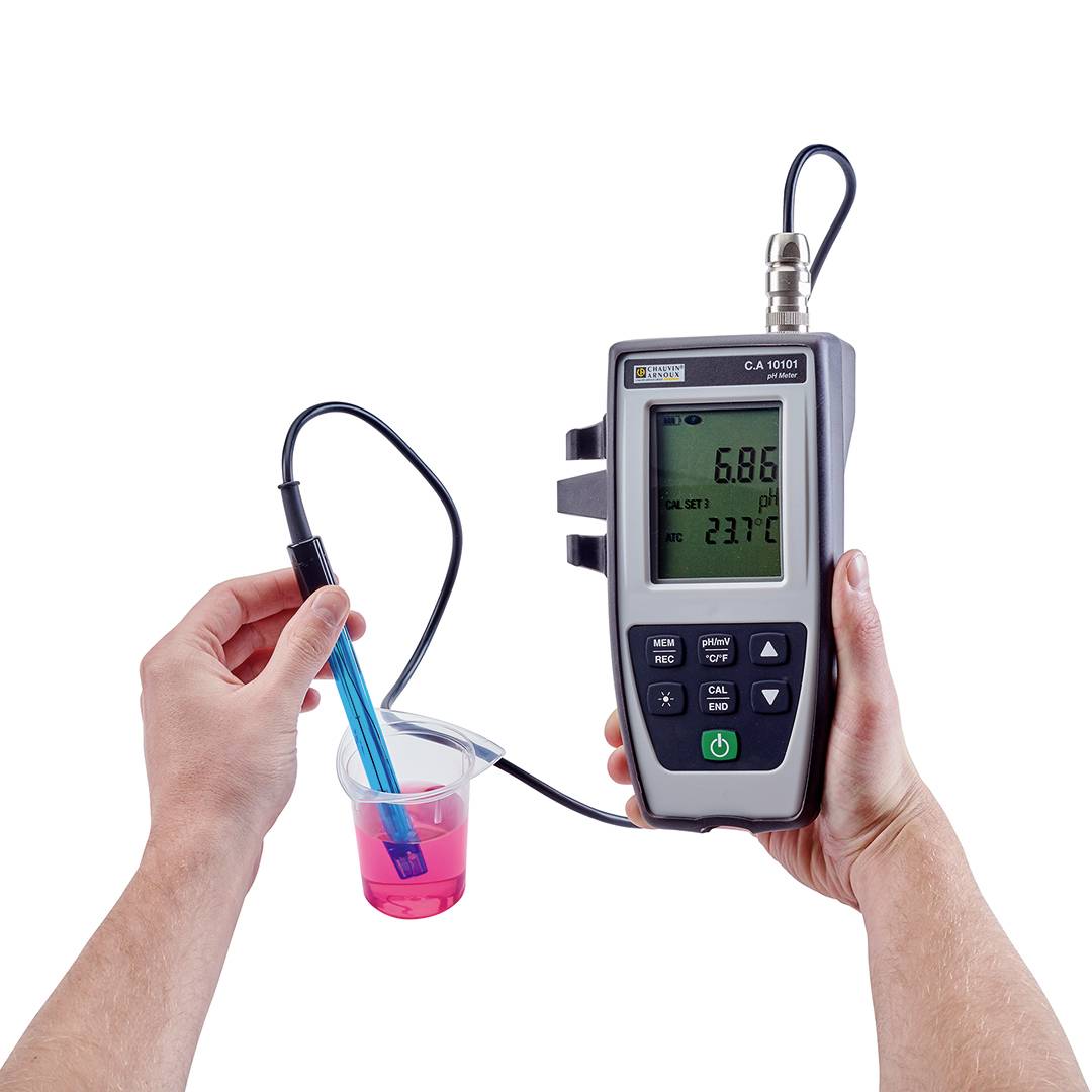 Eine Hand hält ein pH-Meter, das in einem pinken Flüssigkeitsbecher misst. Das Display zeigt pH 5,86 und 23,7°C.