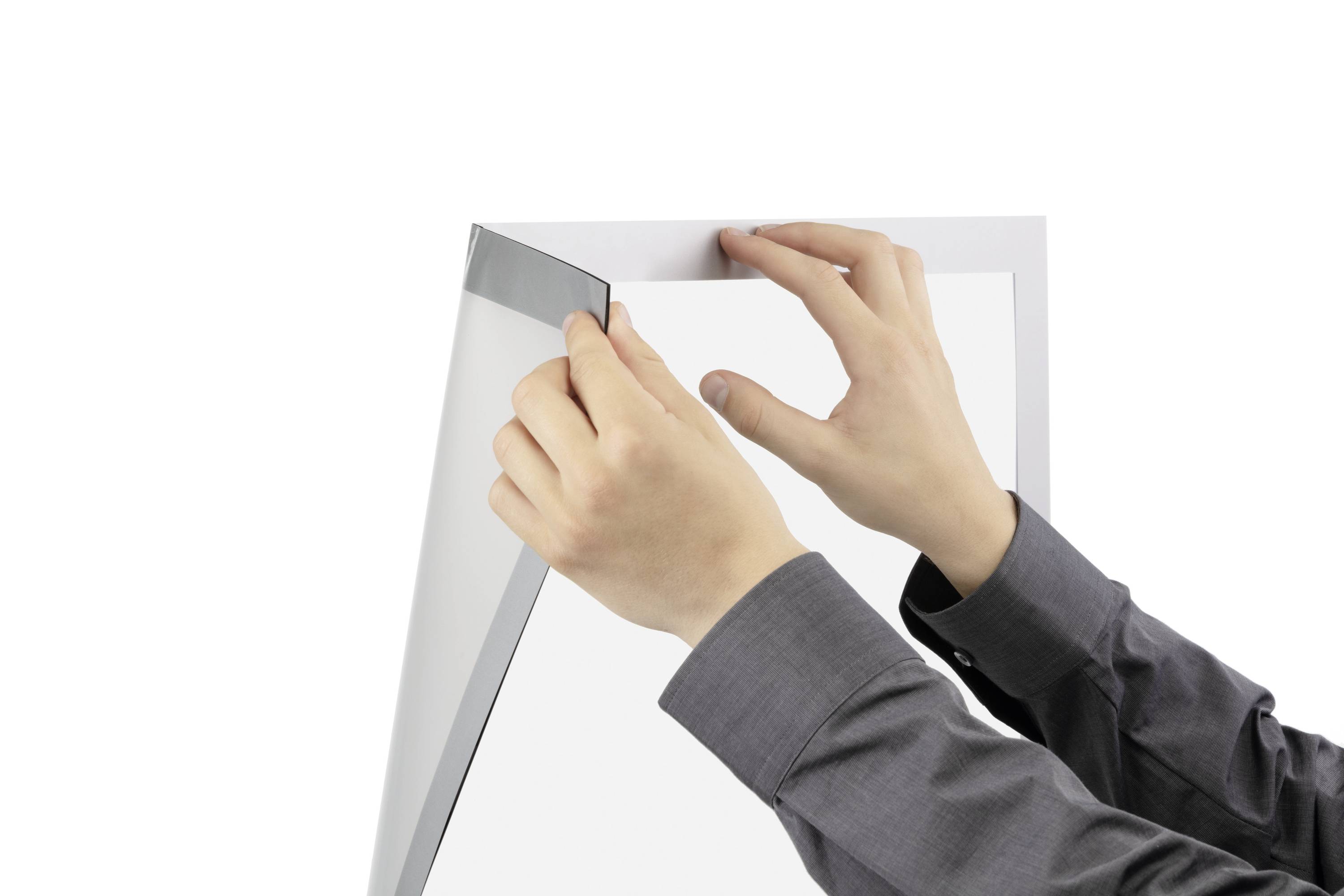 Eine Person hält ein Plakat und zieht eine transparente Schutzfolie ab.
