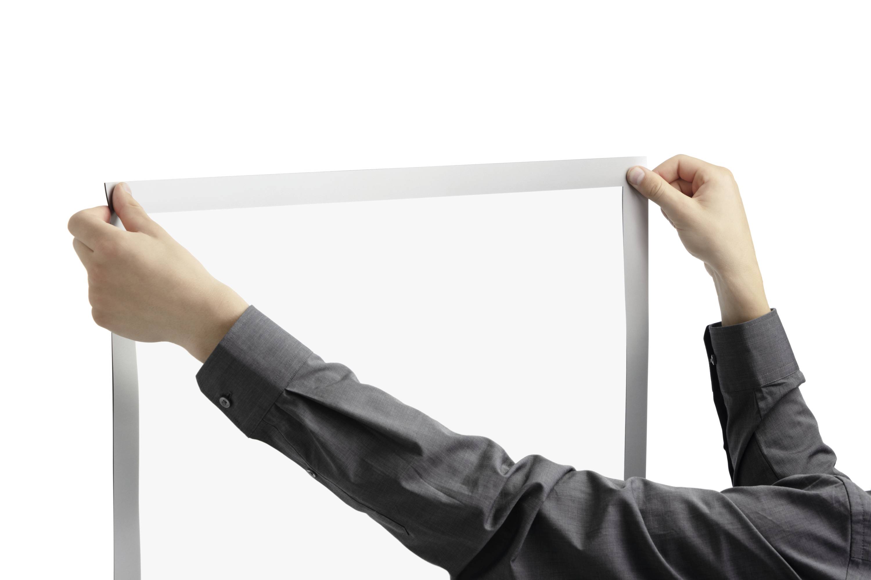 Person hält ein leeres Blatt Papier, bereit zum Beschreiben oder Zeichnen. Hände in Hemdärmeln sind sichtbar. Klare, neutrale Szene.