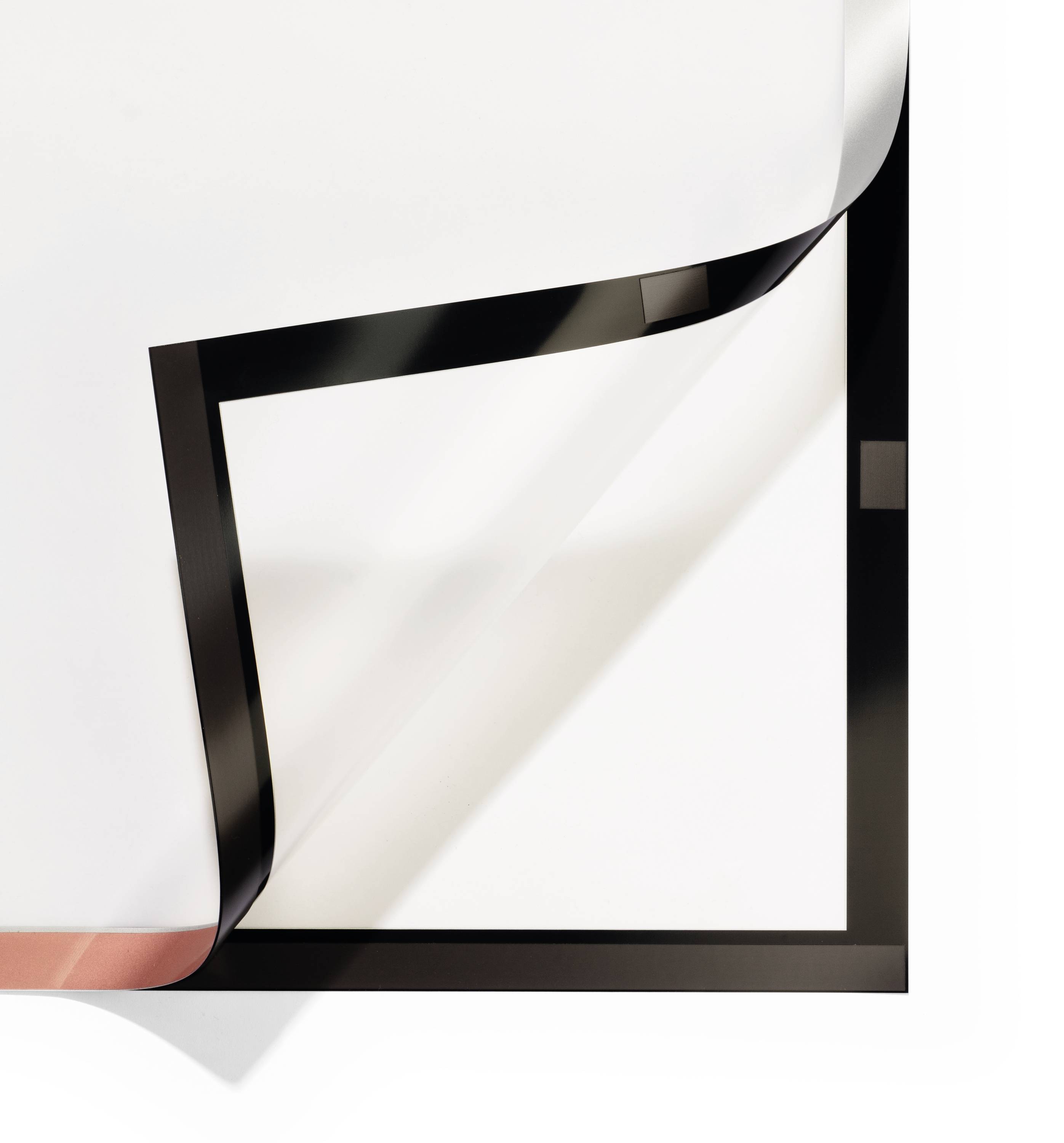 Ein weißes Blatt Papier wird von der rechten oberen Ecke diagonal nach unten gefaltet und zeigt eine schwarze Rückseite.