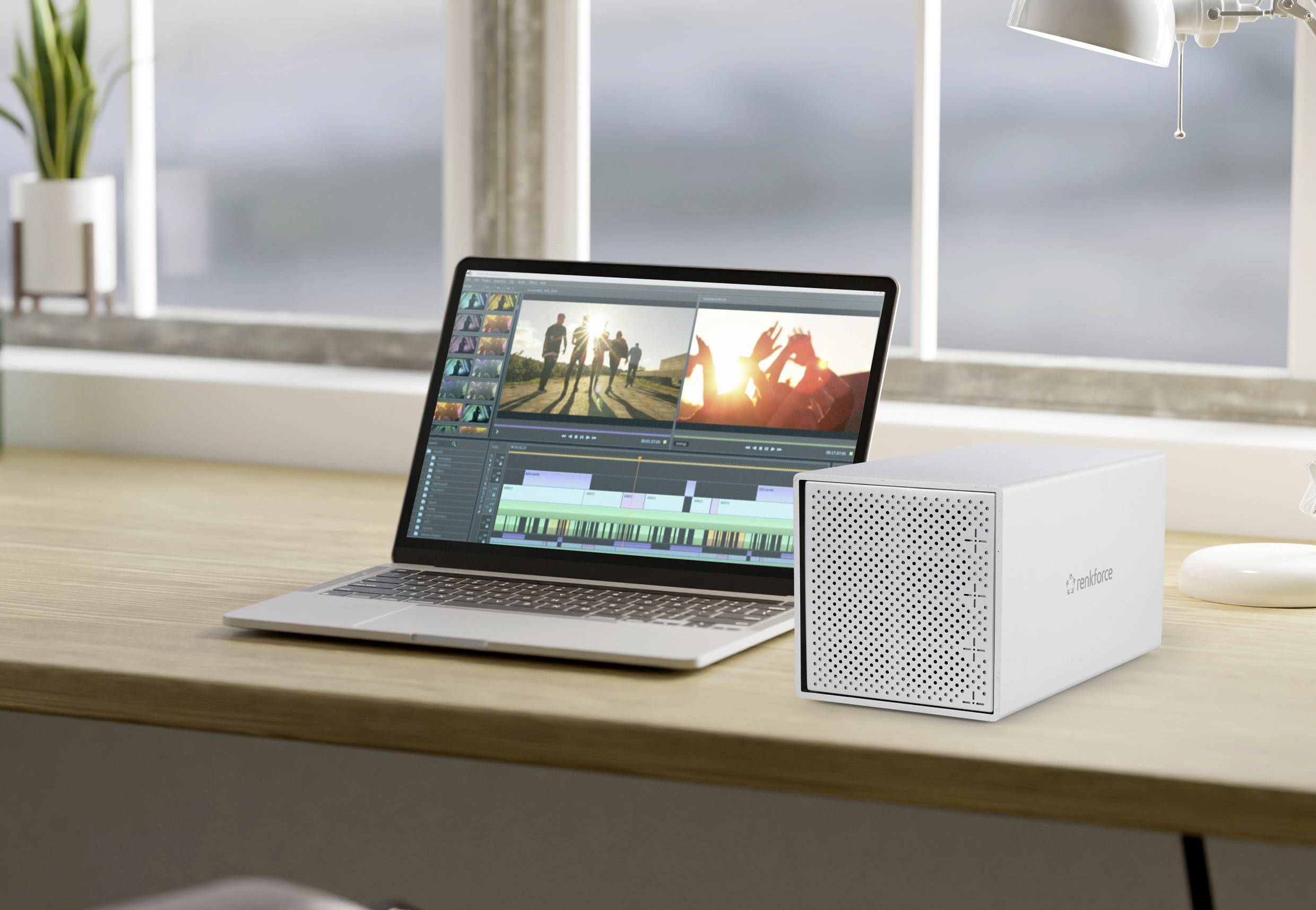 Ein Laptop auf einem Tisch zeigt ein Videobearbeitungsprogramm. Daneben steht ein kompaktes, weißes Speichergerät.