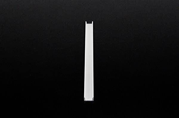 Ein einzelnes weißes Lineal liegt vertikal auf einem schwarzen Hintergrund.