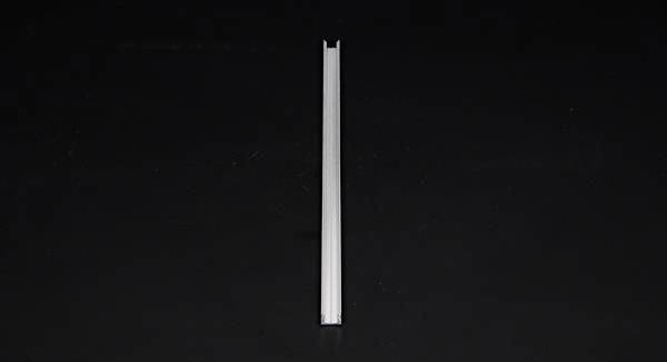 Ein einzelner, schmaler, senkrechter Stab steht vor einem schwarzen Hintergrund.