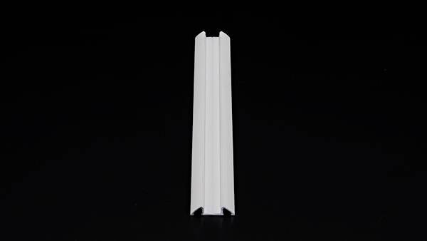 Ein weißes Kunststoffprofil mit V-förmiger Kerbe auf schwarzem Hintergrund.