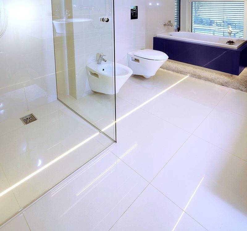 Modernes Badezimmer mit gläserner Duschkabine, separater Badewanne, Toilette und Bidet. Große Fenster lassen viel Tageslicht herein.