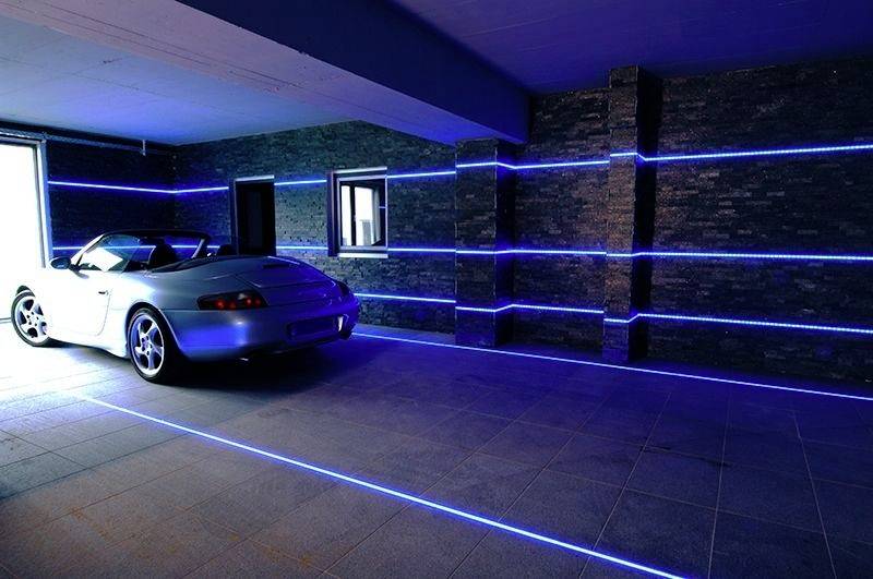 Ein blauer Sportwagen steht in einer modern beleuchteten Garage. Blaue LED-Streifen an den Wänden heben das Fahrzeug hervor.