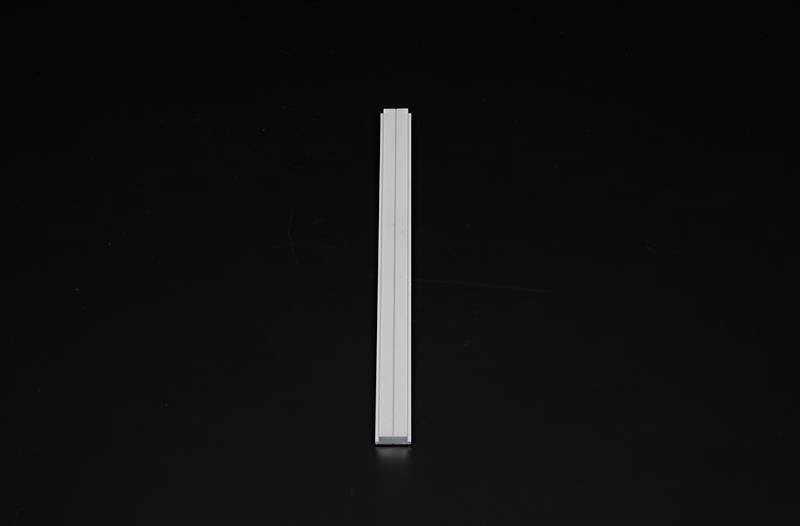 Metallprofil auf schwarzem Hintergrund, vertikal zentriert.