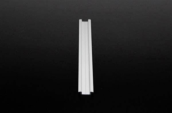 Eine lange, schmale, weiße Leiste liegt horizontal auf einem schwarzen Hintergrund.
