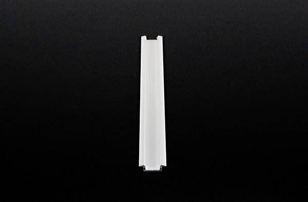 Ein weißes, rechteckiges Kunststoffteil auf schwarzem Hintergrund.