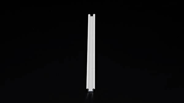 Vertikaler metallischer I-förmiger Balken vor schwarzem Hintergrund.